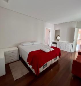 索科罗Casa alto padrão em Socorro的白色卧室配有一张带红色毯子的大床