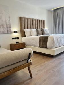 萨莫拉-德伊达尔戈梅松德瓦耶酒店的一间卧室配有两张床,内设长凳
