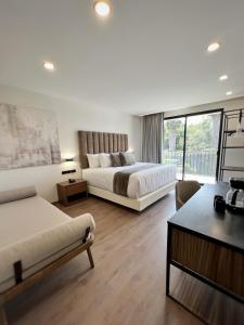 萨莫拉-德伊达尔戈梅松德瓦耶酒店的大型酒店客房 - 带两张床和一张沙发