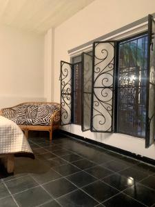 塔斯科·德·阿拉尔孔CasaBambu Taxco的一间设有斑马印花椅和窗户的客房