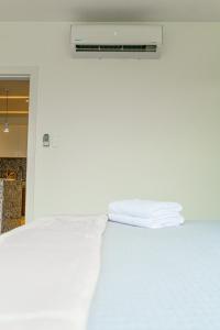 瓜亚基尔Luxury Apartments estilo New York的一张带白色床单和毛巾的床