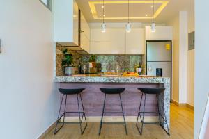 瓜亚基尔Luxury Apartments estilo New York的厨房配有带凳子的柜台