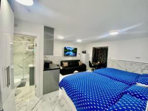 海斯THE ROYAL BOUTIQUE STUDIO by LONDON SLEEP 6的一间带蓝色床的卧室和一间浴室