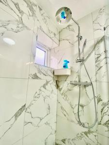 海斯THE ROYAL BOUTIQUE STUDIO by LONDON SLEEP 6的浴室设有大理石瓷砖和淋浴。