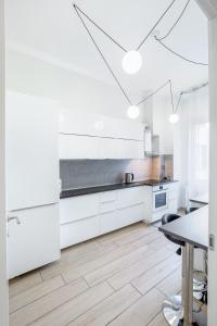 热那亚Waterfront District Apartment的白色的厨房配有白色的橱柜和桌子