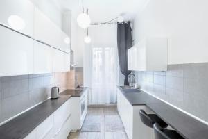 热那亚Waterfront District Apartment的厨房配有白色橱柜和黑色台面