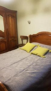 Le GenestLe Genest St Isles的一间卧室配有一张带两个黄色枕头的床