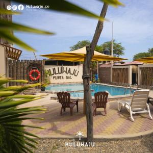 La BocanaHuluwaju Hotel的度假村前方的带椅子和遮阳伞的游泳池