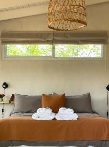 诺诺Las Quimeras的床上的床铺,上面有毛巾,还有窗户