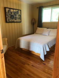 里穆斯基Le chalet du Golf à Rimouski的一间卧室设有一张床和一个窗口