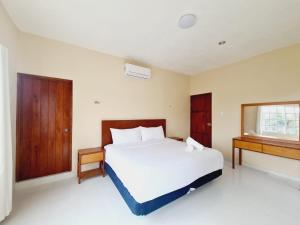 Dzilam de BravoCasa Azul Cielo的卧室设有一张白色大床和一扇窗户。