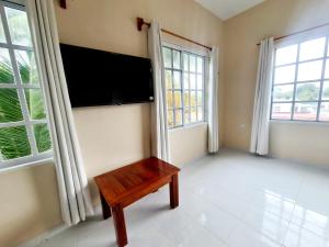 Dzilam de BravoCasa Azul Cielo的客厅配有平面电视和长凳。