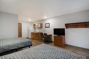 辛普森维尔WoodSpring Suites Greenville Simpsonville的带两张床的客房和带电视的厨房