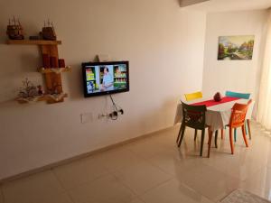 甘达坞伊港Résidence Sayadi - Chatt Meriam - Sousse的一间设有桌子的用餐室和墙上的电视