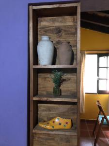 科尔多瓦Prana Eco hospedaje的木架,带三个花瓶和一个枕头