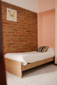 埃斯克尔Hotel Pintó Terraza的卧室配有床,靠砖墙