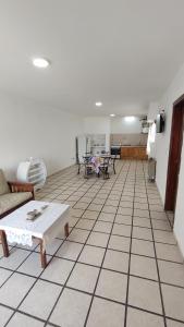 内科切阿Departamento en Necochea的客厅铺有瓷砖地板,配有沙发和桌子