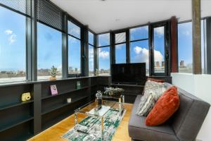伦敦Luxury Central London Penthouse的带沙发、电视和窗户的客厅