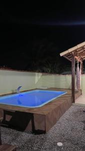 卡波布里奥Casa Unamar的大型蓝色游泳池,晚上设有木甲板