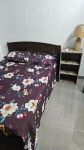 Petit RaffraySK Residence的一间卧室配有一张带花卉床罩的床