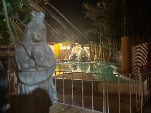 帕纳哈切尔Hotel & Restaurante Hanna Resort的一座雕像,在游泳池旁的围栏前