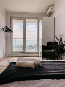 布达佩斯Highrise Horizon Penthouse的一间卧室设有一张大床和大窗户