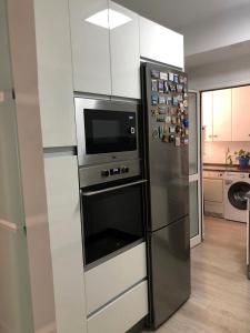 安特克拉Apartamento Parquesol的厨房配有带微波炉的不锈钢冰箱