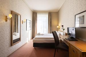 因特拉肯Grand Hotel Beau Rivage Interlaken的配有一张床和一张书桌的酒店客房
