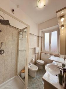 瓦拉泽Casa vacanze LA NINA的浴室配有卫生间、盥洗盆和浴缸。