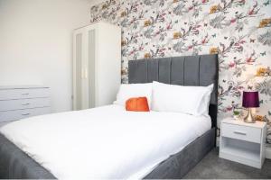GoodmayesA hidden Gem in the heart of Dagenham!的一间卧室配有一张床和花卉壁纸