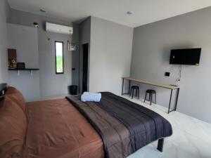 Chai Natเช็คอินรีสอร์ท Check-in Resort的一间卧室配有一张大床和一张书桌
