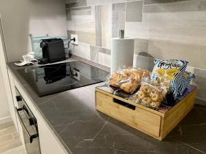 米兰Modern-House • Fiera Milano (MiCo) • City Life的厨房柜台,备有一盒面包和小吃