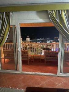 艾因苏赫纳Porto Sokhna Pyramids Apartments的阳台,晚上可欣赏到城市景观
