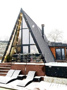 RakovacForrest Relax & Spa的一座有三角形屋顶的雪地建筑