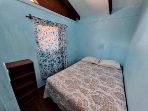 安加罗阿Cabañas puna poho的一间带床和窗帘的小卧室