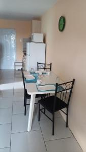 威廉斯塔德Dushi Curaçaose appartement的餐桌、两把椅子和冰箱