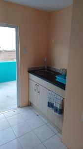 威廉斯塔德Dushi Curaçaose appartement的一个带水槽的厨房,享有游泳池的景色