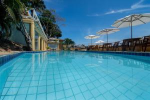 布希奥斯Pousada e Spa Villa Mercedes by Latitud Hoteles的一个带椅子和遮阳伞的大型游泳池