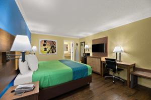 基西米SureStay Hotel by Best Western Clermont Theme Park West的配有一张床和一张书桌的酒店客房