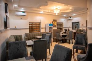 OnitshaAbada Luxury Hotel and Suites的一间在房间内配有桌椅的餐厅