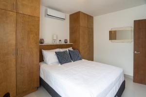 恩塞纳达港Viñedos del Mar的卧室配有一张白色大床和木制橱柜。