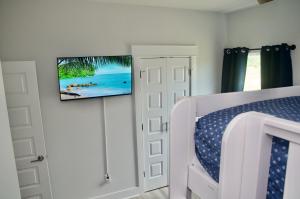 巴拿马城海滩Peaceful Shores Retreat的一间卧室配有一张床,墙上配有电视