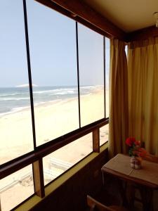 AricaArica Surf & Beach House的客房设有可欣赏海滩景致的窗户。