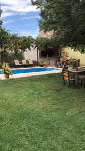迈普Posada del vino的游泳池旁的庭院配有桌椅