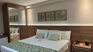 多明戈斯马丁斯Vista Azul Hotel的一间卧室配有一张带白色床单的大床