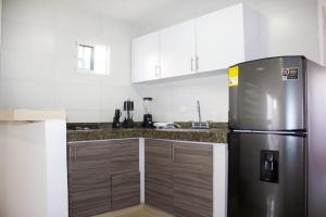 巴耶杜帕尔APARTAMENTO VALLEDUPAR的厨房配有冰箱和木制橱柜。