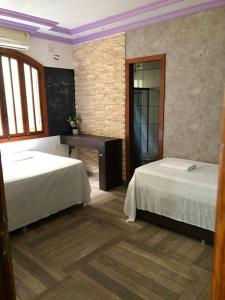 瓜拉派瑞Casa em Guarapari - Airbnb do capitão Jefferson的客房设有两张床、一张书桌和一个黑板