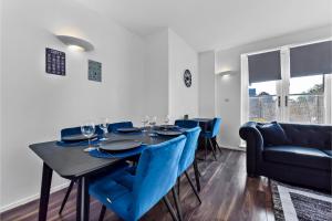 伦敦Charming and Modern 2 BR Flat的一间用餐室,配有黑桌和蓝色的椅子