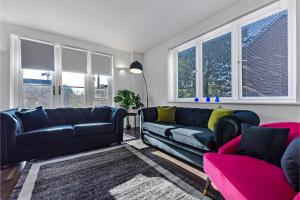 伦敦Charming and Modern 2 BR Flat的客厅配有黑色皮革家具和窗户。