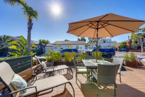 圣地亚哥Stunning Beach Home - large patio, parking, ac & dog friendly!的庭院内桌椅和遮阳伞